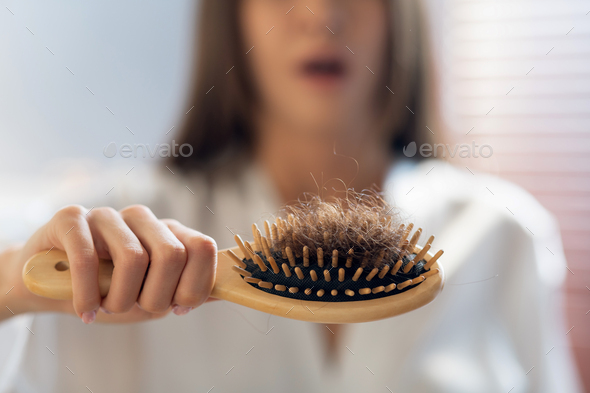 Hairloss Concept. Worried Woman Holding Comb Full Of Fallen Hair After  Brushing Stock Photo by Prostock-studio