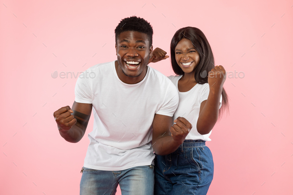 Portrait of happy young black couple shaking clenched fists