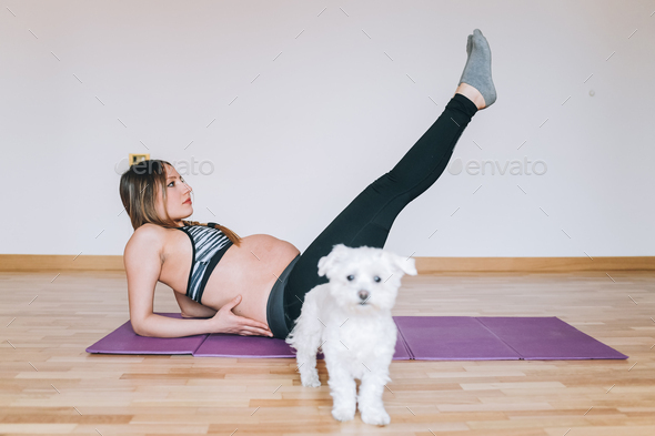young pregnant woman indoor doing yoga - healthy lifestyle, relaxing, self improvement concept