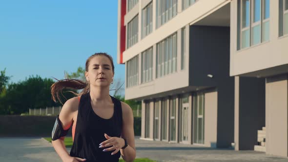 Girl in Black Tracksuit Start Runs Past Modern Building on Street alt