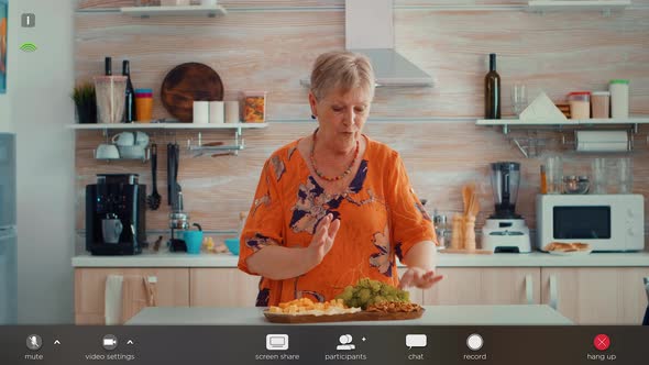 Elderly Woman Having a Video Call in the Kitchen alt