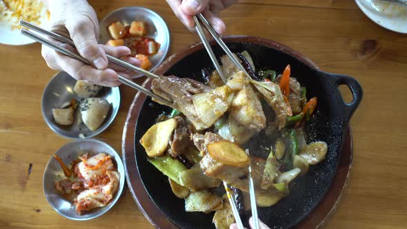 Hands Eating Korean Pork Ribs On Hot Pan Together