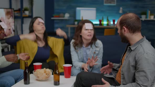 Mixed Race Friends Socializing During Creative Party While Playing Funny Guess Who Game alt