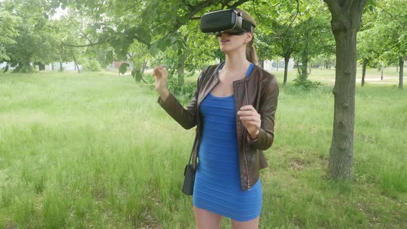 Young Cheerful Woman Uses Modern Helmet Of Virtual Reality On Nature