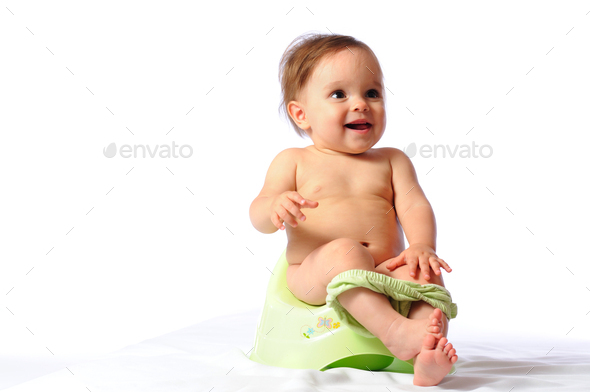 Funny baby sitting on green potty