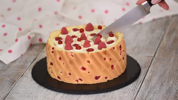 Cutting a Raspberry Mousse French Dessert