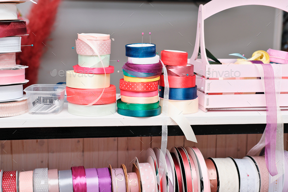 gift wrapping ribbons on a counter in a flower shop. various colors of ribbons for presents.