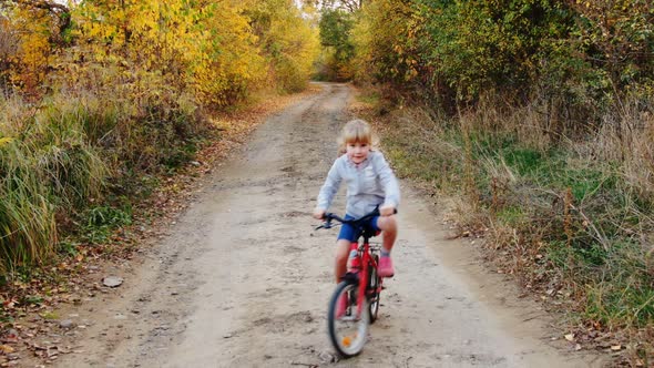 Aerial Drone View Girl Rides Bicycle on Countryside Road