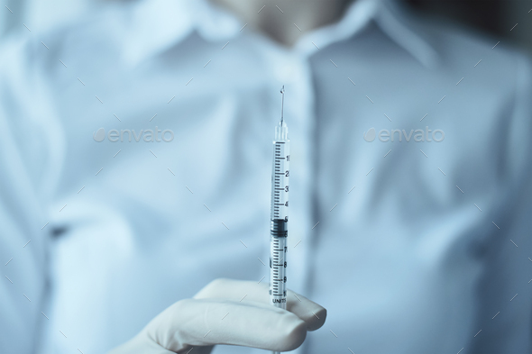 Woman in gloves hold injection syringe, closeup Healthcare, medical and virus protection concept
