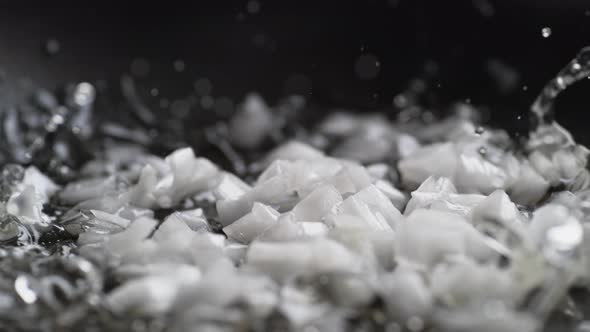 Putting chopped onion on heated non stick fry pan. Slow Motion. alt