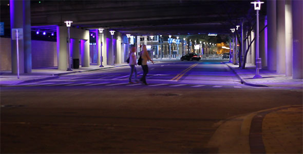 Two Women Cross A City Street At Night