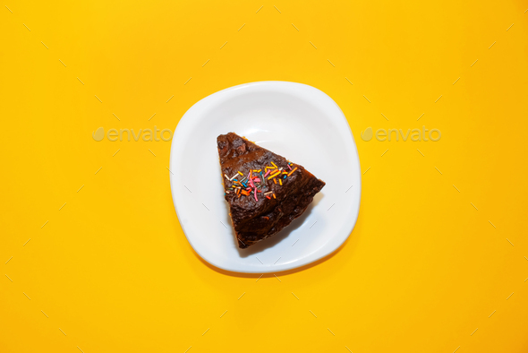 Piece of cake on a plate, top view. Decorated chocolate brownie.