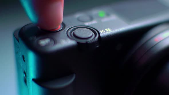 the Finger Presses the Red Recording Button of the Video Camera and the Red Light Turns on alt