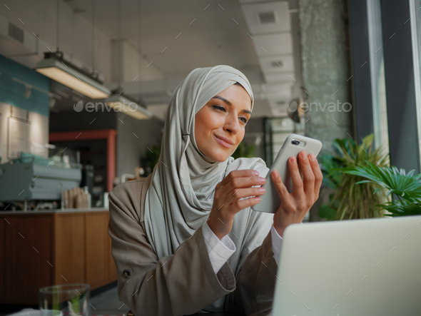 Muslim woman on remote working, online education or video conversation in caffe - Stock Photo - Images