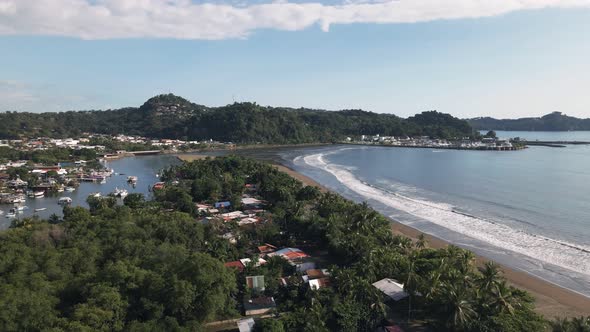 The port city of Quepos, Costa Rica on a sunny day viewed from Isla Damas. Ascending aerial shot alt