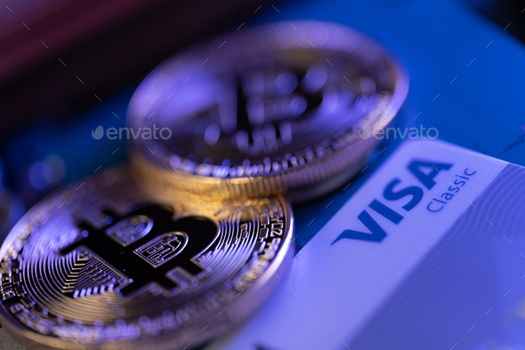 Golden coin with bitcoin symbol and Visa card