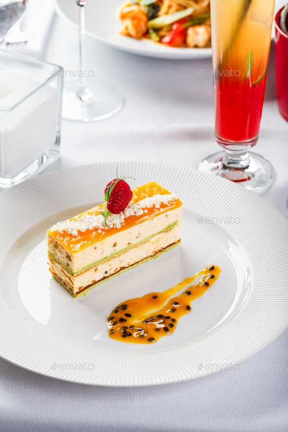 Portion dessert mousse cake with pistachios and passion fruit tropical fruits