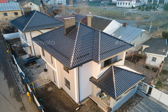 Aerial view of private house with ceramic shingles covered roof top. Investment in real estate