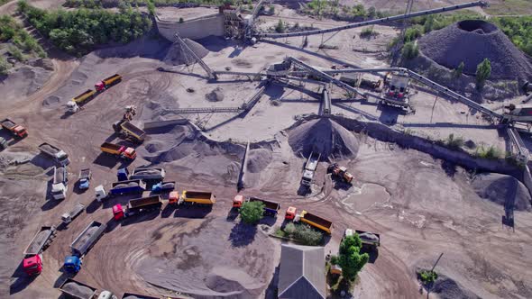 Excavators and Tractors Load Crushed Stone and Rock Into Dump Trucks alt