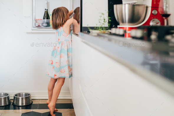 hungry female children irresistibly hungry searching for food in the fridge tiptoeing