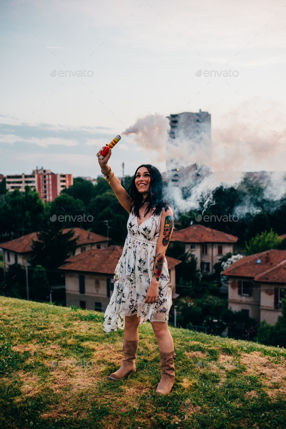 young woman outdoor using smoke flare