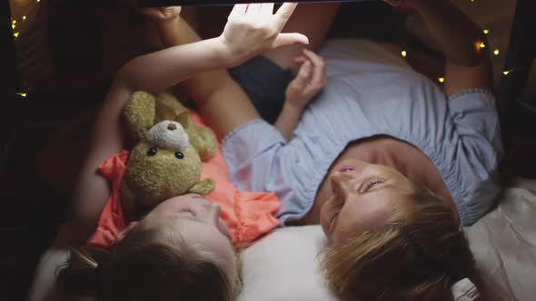 Caucasian woman playing with her daughter at home alt