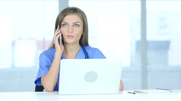 Young Female Doctor Talking on Phone in Hospital alt