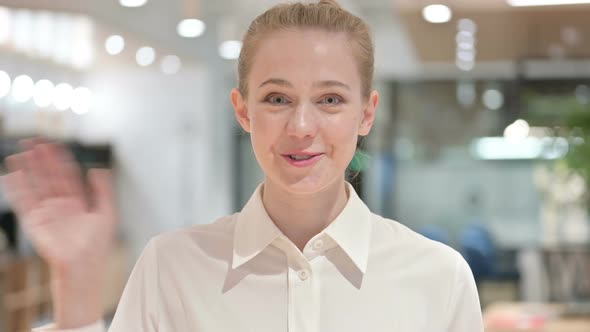 Portrait of Cheerful Young Businesswoman Waving at the Camera  alt