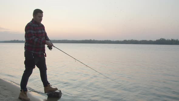 Male Angler Taking Selfie with Fish Near Water