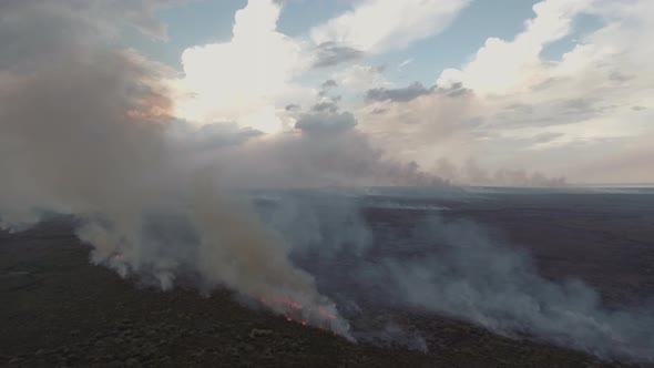 Aerial view of a small wildfire burning vegetation, Cambodia. alt