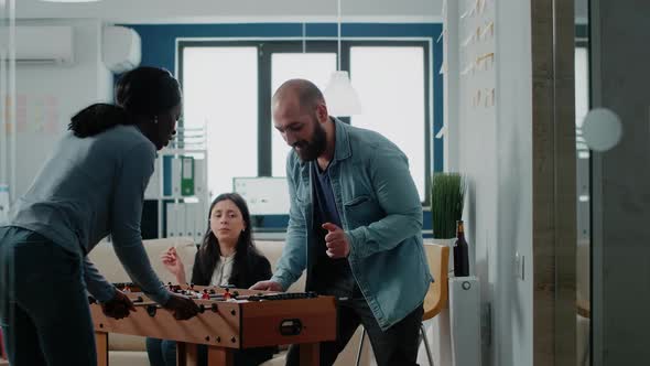 Multi Ethnic Colleagues Enjoying Play at Foosball Table alt