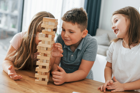 Focused on the jumbling tower game. Kids having fun in the domestic ...