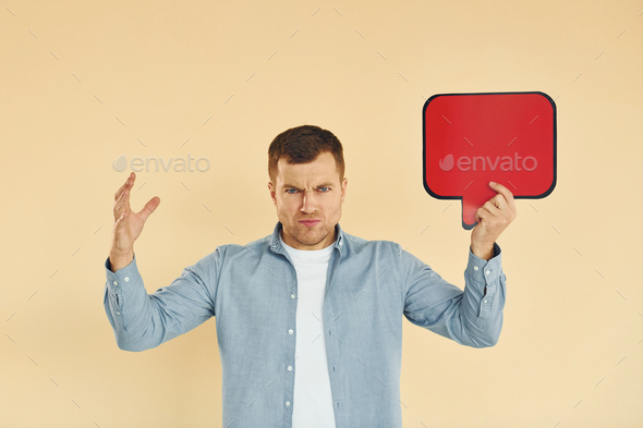 Angry and mad. Man standing in the studio with empty signs for the text