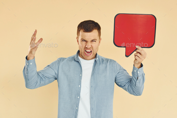 Angry and mad. Man standing in the studio with empty signs for the text