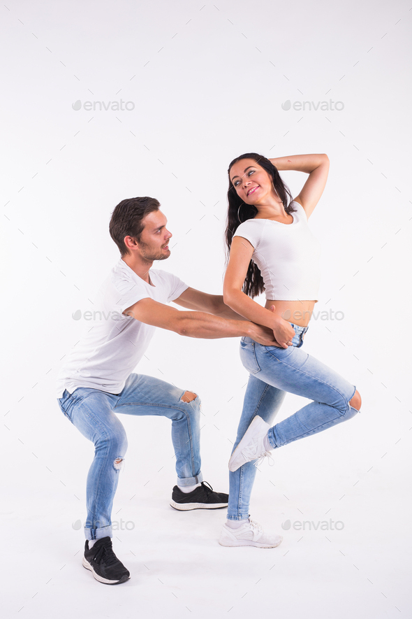 Young couple dancing social latin dance bachata, merengue, salsa. Two elegance pose on white