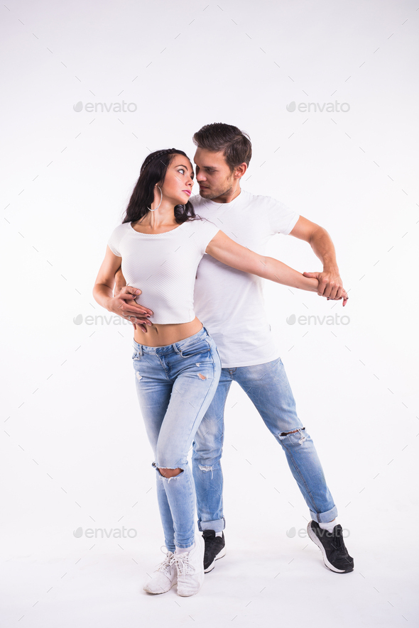 Young couple dancing social latin dance bachata, merengue, salsa. Two elegance pose on white