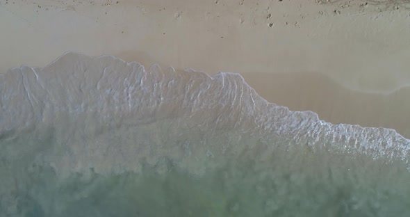 Splash of waves on a beach in the Dominican Republic, with white sand, shot with drone alt
