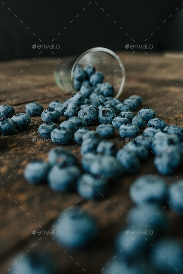 blueberries filled in a transparent glass and scattered Stock Photo by