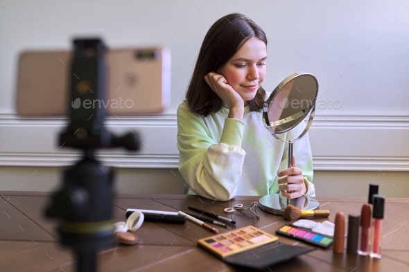 Teen blogger with make-up mirror and makeup