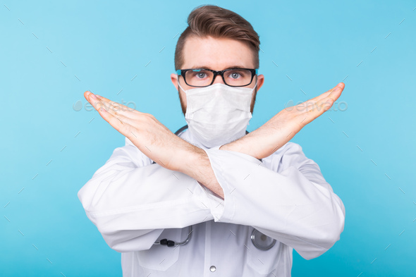 Medical male doctor wear a mask to prevent coronavirus 2019 and standing and raising hand to show