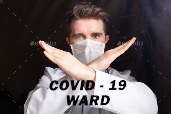 Medical male doctor wear a mask to prevent coronavirus 2019 and standing and raising hand to show