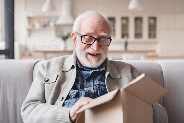 Grandfather opening receiving post parcel delivery, presents gifts ordering goods online on Internet