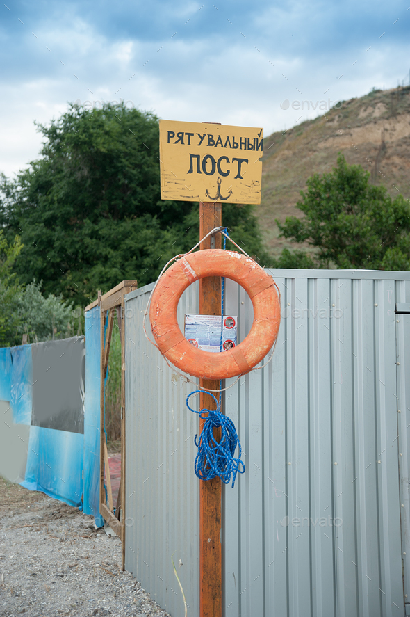 Rescue station on beach on sunny day. sign on the shore. Text in Ukrainian: rescue post. Red life