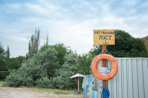 Rescue station on beach on sunny day. sign on the shore. Text in Ukrainian: rescue post. Red life