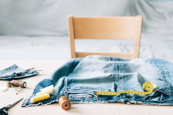 The concept of reusing old recyclable materials. Sewing and repair denim clothes