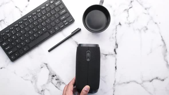 Man Hand Turning on Smart Speaker Top Down 
