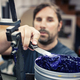 Male Worker Holding Spatula On Blue Ink Container In Industry - PhotoDune Item for Sale
