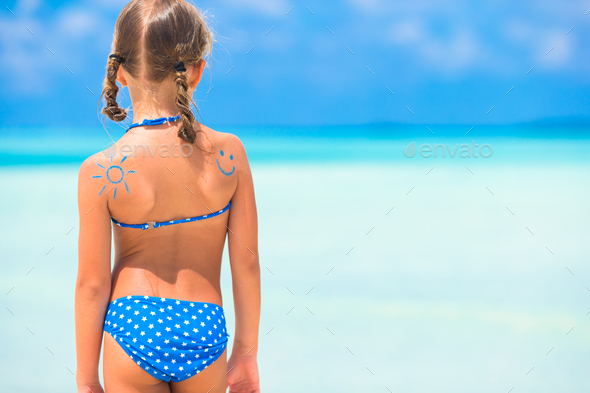 Child protection sun cream on the beach - Stock Photo - Images