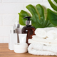 Bottle of soap and stack of towels in white bathroom. - PhotoDune Item for Sale