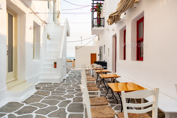 Paros island Naousa Greece. Building cobblestone alley outdoor cafe tavern summer day.